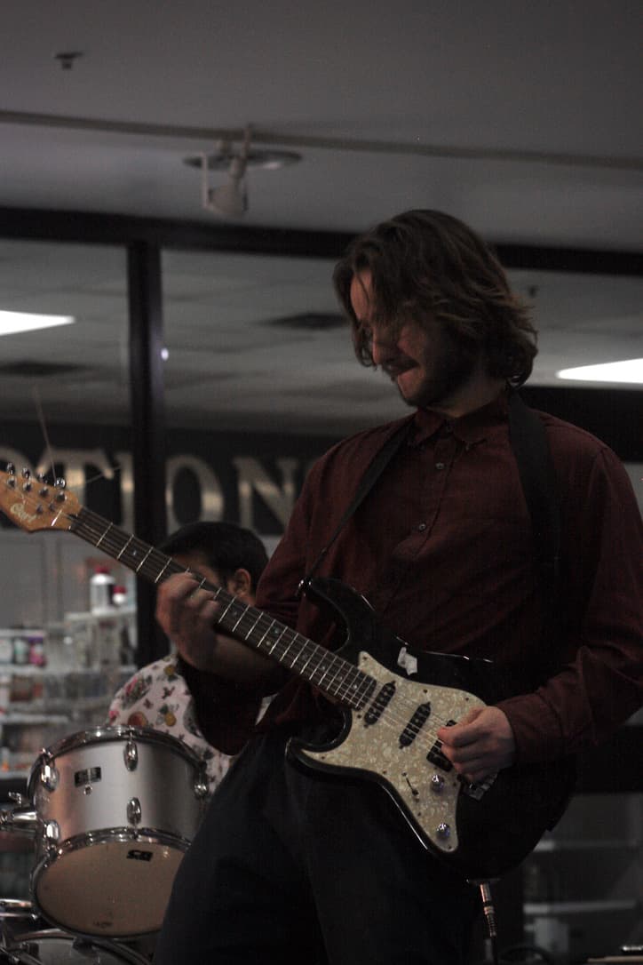 Person standing playing electric guitar.